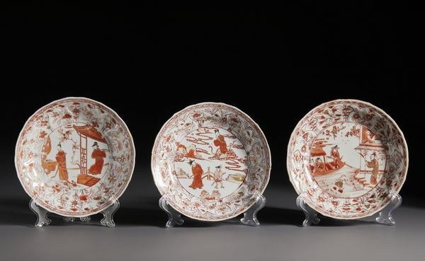 Arte Cinese : Gruppo di tre bei piatti in porcellana decorati in rosso ferro e oro raffiguranti al centro scene tratte dal famoso racconto � The Romance of the Western Chamber �.Cina, Dinastia Qing periodo Kangxi.  - Asta Asta 470 | ARTE ORIENTALE Online - Associazione Nazionale - Case d'Asta italiane