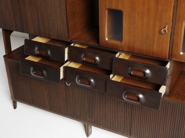 MANIFATTURA ITALIANA : Mobile da soggiorno con ribalta internamente illuminata, stipi ad ante, cassetti, vani a giorno  - Asta Asta 476 | DESIGN E ARTI DECORATIVE DEL NOVECENTO Online - Associazione Nazionale - Case d'Asta italiane