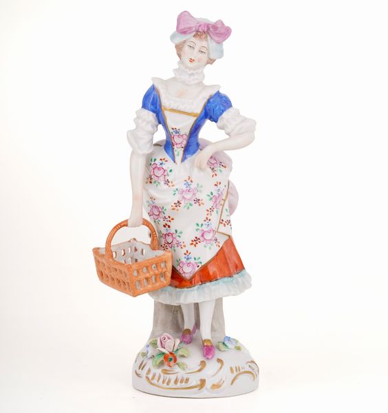 Figurina di giovane con cestino.<BR>Germania, Turingia, Manifattura di Sitzendorf, XX secolo.  - Asta Maioliche, Porcellane e Vetri - Associazione Nazionale - Case d'Asta italiane