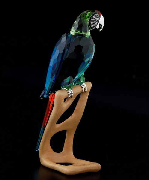 Grande pappagallo Ara sul trespolo.<BR>Swarovski dalla collezione Uccelli paradiso.  - Asta Maioliche, Porcellane e Vetri - Associazione Nazionale - Case d'Asta italiane