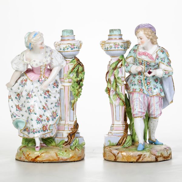 Coppia di candelieri figurati.<BR>Germania, Manifattura di Sitzendorf (Turingia), fine XIX o inizio XX secolo.  - Asta Maioliche, Porcellane e Vetri - Associazione Nazionale - Case d'Asta italiane