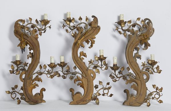 MANIFATTURA DEL XVIII-XIX SECOLO : Tre appliques in legno e metallo dorato, corpo centrale arcuato intagliato a motivo fitomorfo da cui si dipartono bracci in foggia di rami fogliati e fioriti  - Asta Asta 502 | ARTE ANTICA E DEL XIX SECOLO Online - Associazione Nazionale - Case d'Asta italiane