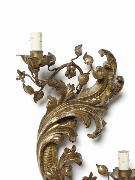 MANIFATTURA DEL XVIII-XIX SECOLO : Tre appliques in legno e metallo dorato, corpo centrale arcuato intagliato a motivo fitomorfo da cui si dipartono bracci in foggia di rami fogliati e fioriti  - Asta Asta 502 | ARTE ANTICA E DEL XIX SECOLO Online - Associazione Nazionale - Case d'Asta italiane