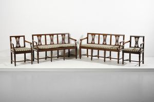 MANIFATTURA ITALIANA DEL XIX SECOLO - Salotto composto da due divanetti e coppia di poltrone in noce, schienali a giorno, gambe troncopiramidali unite da traverse