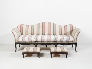 MANIFATTURA DEL XVIII-XIX SECOLO - Divano a tre posti in legno intagliato, grembiale sagomato a motivo rocaille e gambe arcuate, con due poggiapiedi nello stesso stile