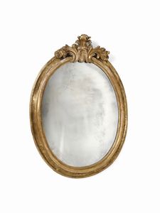 MANIFATTURA DEL XVIII SECOLO - Specchiera di forma ovale in legno intagliato e dorato con cimasa a decoro fitomorfo