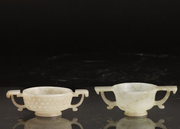 Lotto di due coppette cerimoniale in giada bianca e russet con manici e decori geometrici intagliati, Cina, Dinastia Qing, XVIII secolo  - Asta Fine Asian Works of Art - Associazione Nazionale - Case d'Asta italiane