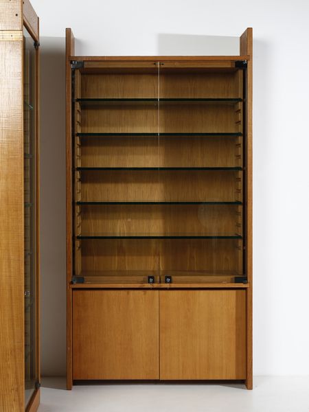 RIVADOSSI GIUSEPPE (n. 1935) : Lotto composto da una libreria a due ante con vetrinetta a cinque ripiani mobili e un mobile espositore da centro a sei ripiani mobili per Officina Rivadossi, Nave  - Asta Asta 516 | DESIGN E ARTI DECORATIVE DEL NOVECENTO Online - Associazione Nazionale - Case d'Asta italiane