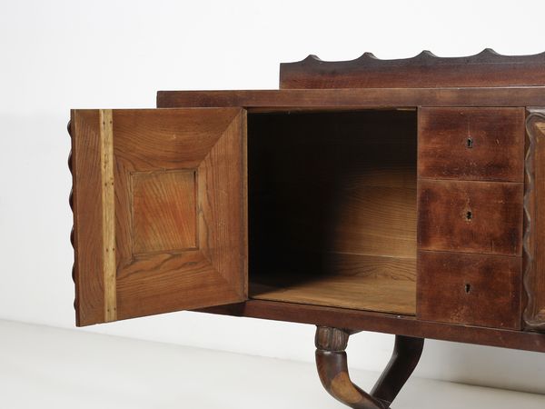 MANIFATTURA ITALIANA : Buffet a sei cassettini, due stipi e vano bar centrale con apertura a ribalta decorati con altorilievi raffiguranti un fanciullo con ariete  - Asta Asta 516 | DESIGN E ARTI DECORATIVE DEL NOVECENTO Online - Associazione Nazionale - Case d'Asta italiane