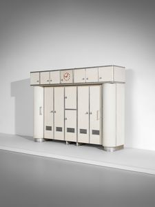 LATIS GUSTAVO (1920-2016) & VITO (1912-1996) - Grande credenza da cucina con parte inferiore a otto stipi dei quali i laterali di forma semicircolare con fronte grissinato. parte superiore a sette ante con orologio nella vano centrale