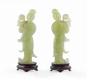 COPPIA DI STATUINE - H cm 18 in giada raffiguranti due donne orientali trattenenti un fiore tra le mani.  Poggianti su basi lignee