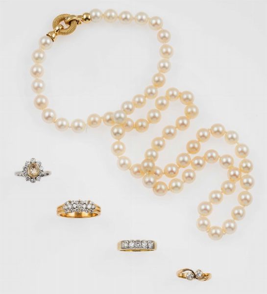 Lotto composto da una collana di perle, un anello con topazio e diamanti a contorno, un anello con cinque diamanti, un anello contrari con due diamanti ed un anello con pav di diamanti  - Asta Fine Jewels - Associazione Nazionale - Case d'Asta italiane