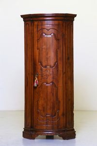 MANIFATTURA VENETA DEL XVIII SECOLO - Angoliera in legno di noce a un'anta intagliata.