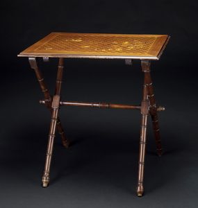 GALLE' EMILE (1846 - 1904) - Tavolino in marqueterie con legni di varia essenza, decori floreali, foglie e di volatile, gambe struttura x a motivi bambou.