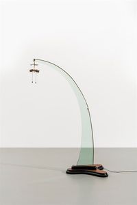 PRODUZIONE ITALIANA - Lampada da terra ad arco con struttura in vetro di forte spessore  base in legno  particolari in ottone. Anni  [..]