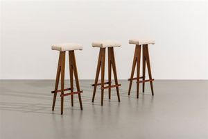 PRODUZIONE ITALIANA - Serie di tre sgabelli con struttura in legno naturale  sedute imbottite rivestite in skai. Anni '50 cm 70x27x1 [..]
