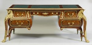 FRANCIA, XIX-XX SECOLO - Scrivania in stile Luigi XVI con bronzi dorati, lostronata e filettata in varie essenze.