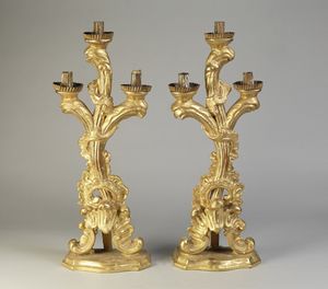 MANIFATTURA LOMBARDA DEL XVIII SECOLO - Coppia di candelabri in legno dorato a tre fiamme.