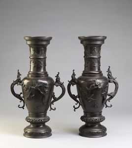 ARTE GIAPPONESE DEL XIX SECOLO - Coppia di vasi in bronzo decorati a rilievo con motivi fogliacei e volatili, anse a forma di drago.