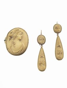 DEMI-PARURE - composta da spilla e coppia di orecchini in metallo dorato  XIX secolo  recante cammei in lava incici con volti  [..]