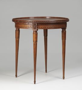 MANIFATTURA FRANCESE DEL XVIII SECOLO - Tavolo tondo in legno intagliato a motivi geometrici, gambe a faretra.