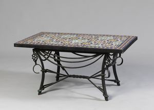 MANIFATTURA DEL XX SECOLO - Tavolino con piano in ceramica invetriata, a mosaico policromo, con sostegno in ferro battuto.