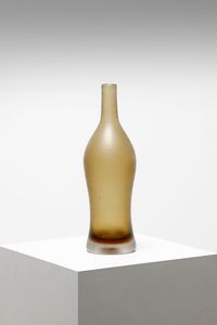 VENINI PAOLO (1895 - 1959) - Grande bottiglia in vetro pesante sommerso in color ambra e aranciato. Superficie rifinita da leggere incisioni orizzontali. Modello 4815 catalogo Venini.