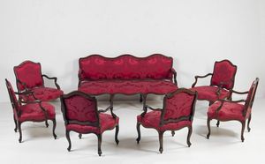 MANIFATTURA FRANCESE DEL XVIII SECOLO - Salotto in legno di noce finemente sagomato composto da divano a tre posti e sei poltrone rivestiti in tessuto rosso.