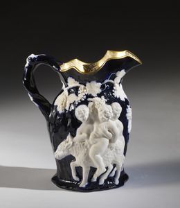 PETIT JACOB (1796 - 1868) - Versatoio in ceramica blu con satiri e vitigni in rilievo nei toni del bianco, decoro ad oro all'interno.