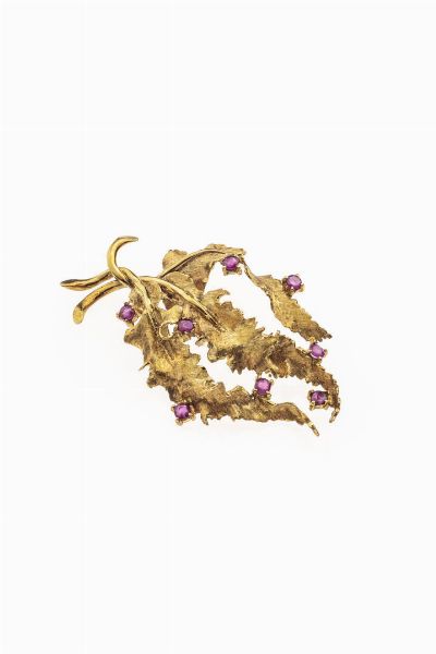 SPILLA : Peso gr 10 6 cm 5x3 in oro giallo satinato raffigurante tre foglie impreziosite da rubini taglio rotondo per totali ct 1 20 ca  - Asta Asta 180 Gioielli - Associazione Nazionale - Case d'Asta italiane