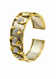 BRACCIALE - Peso gr 80 6 rigido  in oro giallo e bianco  a fascia decorata con volute in diamanti taglio brillante per totali  [..]