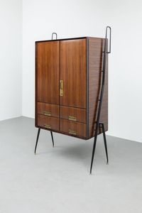 SILVIO CAVATORTA - Mobile contenitore in legno con quattro cassetti  sostegni in metallo verniciato e particolari in ottone. Anni  [..]