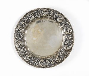 ARGENTIERE DEL XIX SECOLO - Piatto in argento sbalzato con decorazioni vegetali lungo il bordo.