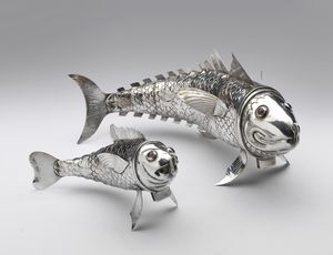 ARGENTIERE DEL XX SECOLO - Coppia di pesci in argento sbalzato con corpo composto da elementi snodabili e occhi in pietre dure.