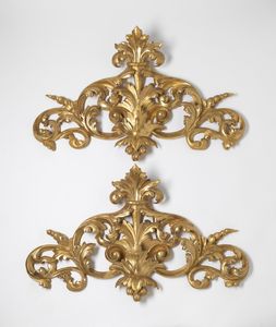 MANIFATTURA DEL XIX SECOLO - Coppia di fregi in legno intagliato e dorato, con decori fitomorfi e a volute.
