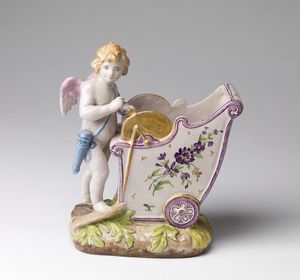 GALL EMILE (1846 - 1904) - Rara fioriera in ceramica raffigurante amorino arrotino, decoro floreale policromo ed oro su base ornata a fogliame.