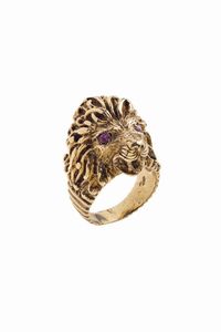 ANELLO - Peso gr 16 8 Misura 16 (56) in oro a bassa caratura a forma di testa di leone. Due rubini sintetici come occhi