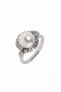 ANELLO - Peso gr 5 5 Misura 16 (56) in oro bianco  con perla giapponese del diam di mm 10 ca trattenuta da onde in diamanti  [..]