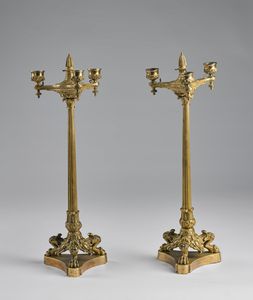 MANIFATTURA DEL XIX SECOLO - Coppia di candelabri in bronzo dorato con fusti a colonne classiche e basi tripodi con zampe a protomi ferine.