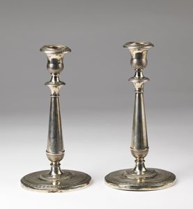 ARGENTIERE VENEZIANO DEL XIX SECOLO - Coppia di candelieri in argento cesellato, con basi circolari, fusto a colonna.