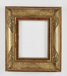 MANIFATTURA FRANCESE DEL XIX SECOLO - Piccola cornice in stile Carlo X  in legno dorato con fregi fitomorfi agli angoli.