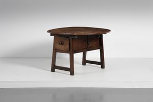 MANIFATTURA DEL XVII SECOLO - Tavolino a bandelle in legno di noce, piano rotondo pieghevole, cassetto sottostante, gambe unite da traverse.