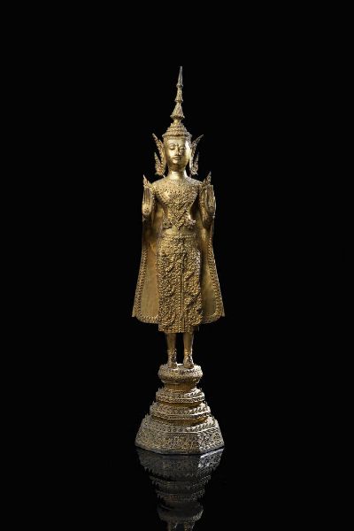 BUDDHA : Figura di Buddha in bronzo dorato nella posizione eretta  Thailandia  XIX secolo. h cm 71 5x18  - Asta Asta 197 Arte orientale - Associazione Nazionale - Case d'Asta italiane