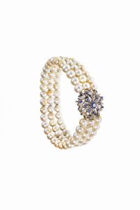 BRACCIALE - composto da tre fili di perle giapponesi del diam di mm 6. Distanziali e fili in oro bianco  Chiusura a fiore  [..]