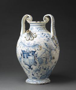 MANIFATTURA DEL XVIII-XIX SECOLO - Grande orciolo biansato in maiolica a smalto bianco e blu, con decori a paesaggi e stemma nobiliare sorretto da figure di putti.