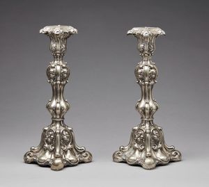 ARGENTIERE DEL XIX-XX SECOLO - Coppia di candelieri in lamina d'argento con decorazioni floreali.