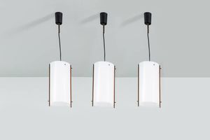PRODUZIONE ITALIANA - Tre lampade a sospensione con diffusori in plexiglass e particolari in legno  attacchi in metallo verniciato.  [..]